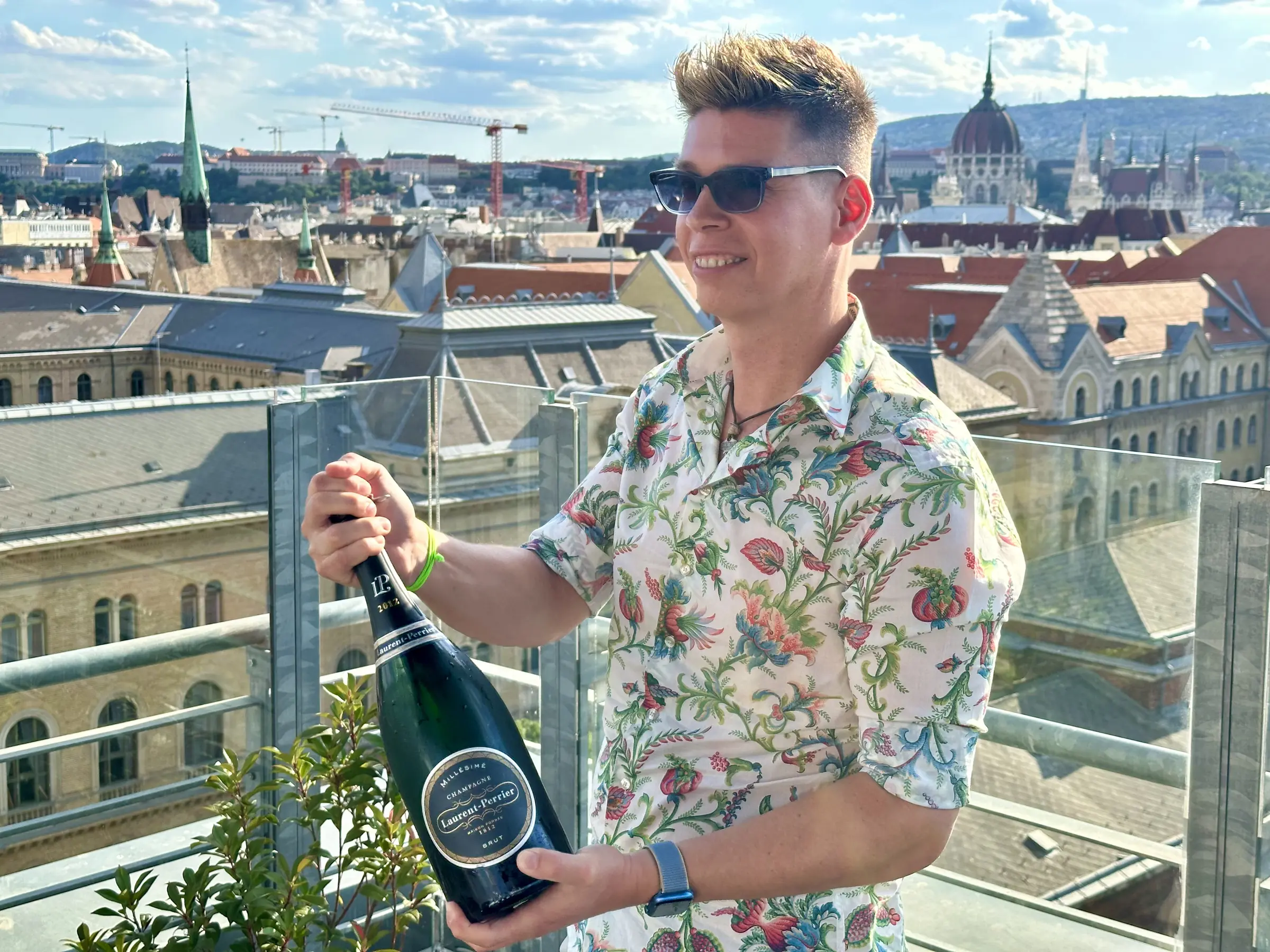 Mate Hajdu with a Laurent-Perrier bottle before the Budapest skyline