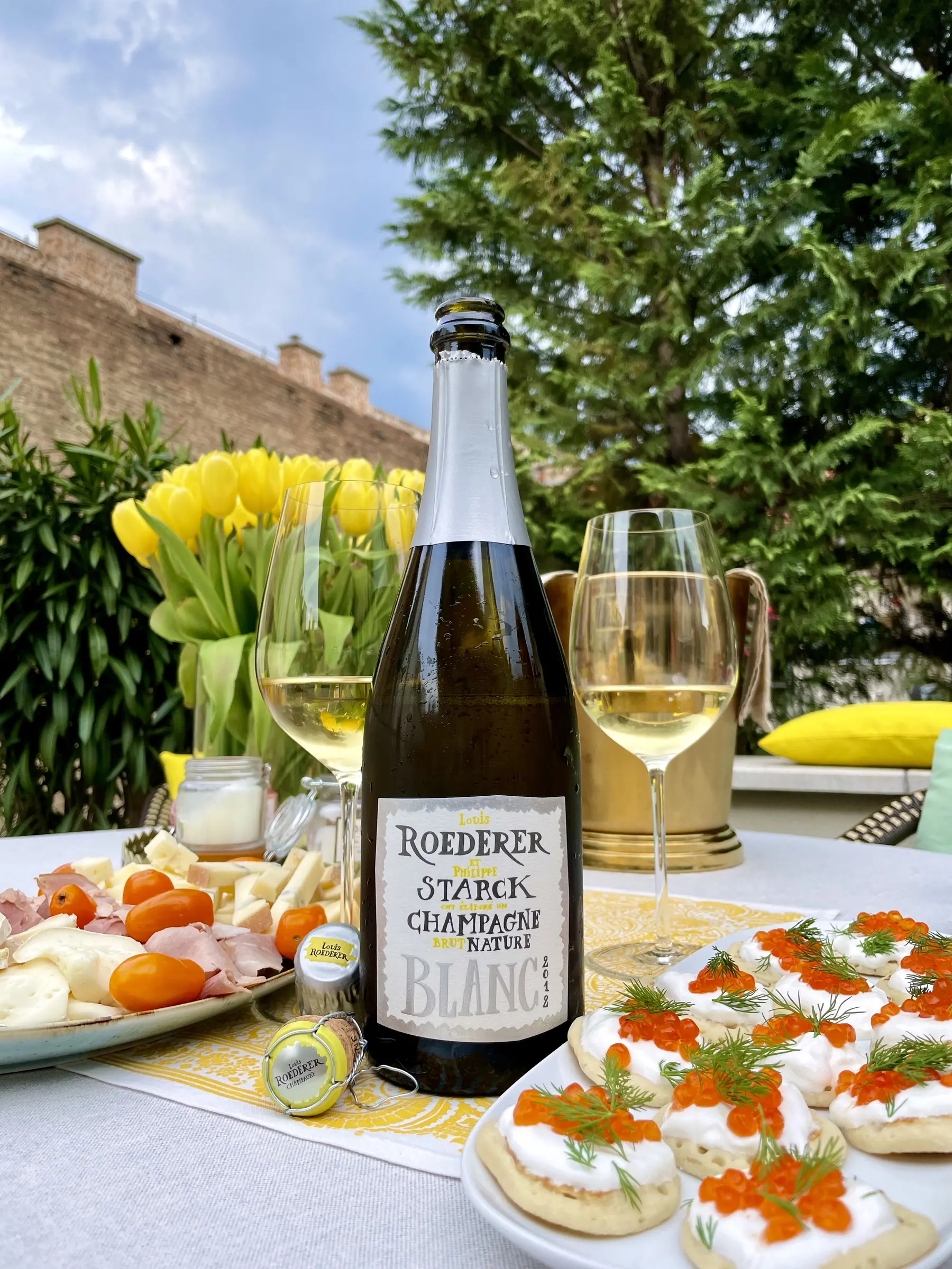 Louis Roederer Brut Nature Champagne on a summer table